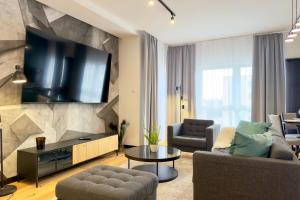 a living room with a flat screen tv on a wall at Apartament Stara Fabryka 15 in Włocławek