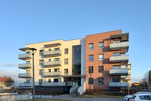 an apartment building with balconies and a parking lot at Apartament Stara Fabryka 15 in Włocławek