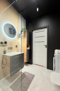 a bathroom with a white door and a toilet at Apartament Stara Fabryka 15 in Włocławek +9 photos