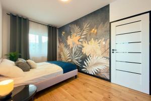 a bedroom with a bed and a wall mural at Apartament Stara Fabryka 15 in Włocławek