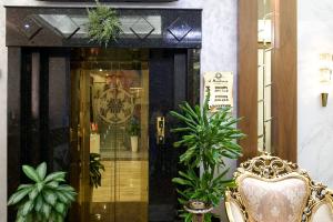 a doorway to a store with a chair and plants at al Madina Hotel Samarkand in Samarkand