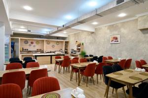 a restaurant with tables and chairs and a kitchen at al Madina Hotel Samarkand in Samarkand