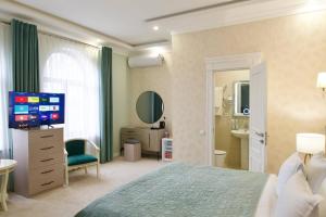 a bedroom with a bed and a television and a bathroom at al Madina Hotel Samarkand in Samarkand