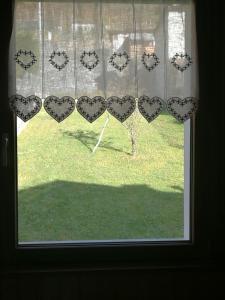 a window with a bunch of hearts on a curtain at Appartamento Ca' Battaglia in Chiesa in Valmalenco
