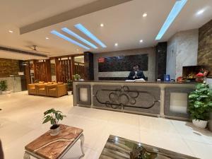 a man standing at a counter in a lobby at Airport Hotel Vella VILLA By Corporate Group Delhi IGI Airport Terminal 3 With Free Airport Pickup in New Delhi