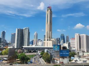 eine Stadtsilhouette mit einem hohen Wolkenkratzer in der Unterkunft Interchange Tower Serviced Apartment - SHA Extra Plus in Bangkok