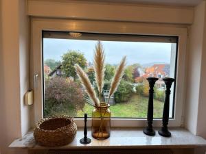 a window with a vase with feathers in it at Ferienwohnung Detmold Diestelbruch in Detmold