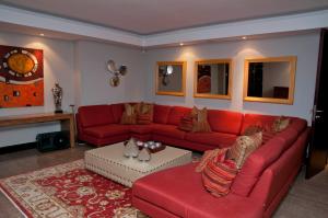 a living room with a red couch and a table at The Mount Knysna in Knysna