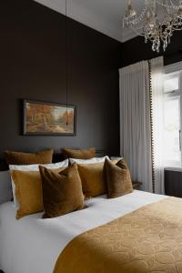 a bedroom with a bed with black walls and a chandelier at Seapoint Cottage, Luxury Accommodation in Napier