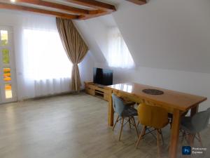 a dining room with a wooden table and chairs at Căsuța din livadă in Secăria