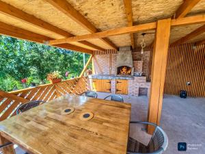 a wooden table on a deck with a fireplace at Căsuța din livadă in Secăria
