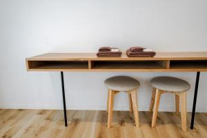 a wooden table with two stools under it at 果実の見える宿 in Koshu