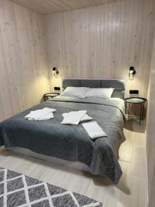 a bedroom with a large bed with towels on it at Porichka Home in Roslavichi