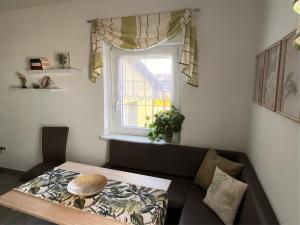 a living room with a couch and a window at Ferienwohnung Hagert - Ankommen und Wohlfühlen in Eibenstock