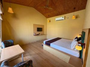 a bedroom with a bed and a table and chairs at Eeja Resto and Cafe in Garappu