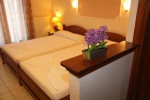 a hotel room with a bed with a flower on a table at Vasiliki Apartments in Platamonas