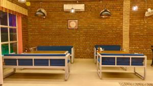a restaurant with blue chairs and a brick wall at Eeja Resto and Cafe in Garappu