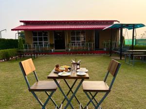 a table and chairs with food on top of it at Eeja Resto and Cafe in Garappu