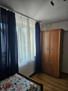 a bedroom with a bed and a wooden cabinet at Noclegi w Dolinie Baryczy in Radziądz