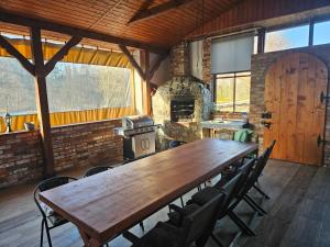 a large wooden table in a room with a fireplace at Noclegi w Dolinie Baryczy in Radziądz