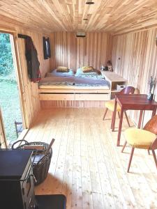 a room with a bed and a table in a cabin at Maringotka Rozálka in Dlouhá Stropnice