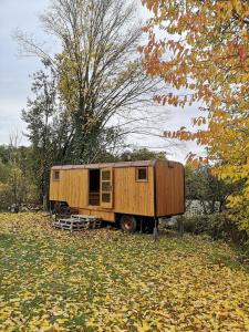 a wooden trailer sitting in a field of leaves at Maringotka Rozálka in Dlouhá Stropnice +10 photos