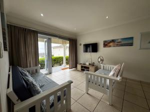 a bedroom with a crib and a tv in a room at Mangrove Beach Estate Boboyi in Port Shepstone