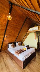 a large bed in a room with a wooden ceiling at Mountain View A frame Pool Villa in Meppādi