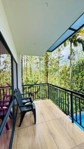 a balcony with a chair and a view of the forest at Mountain View A frame Pool Villa in Meppādi