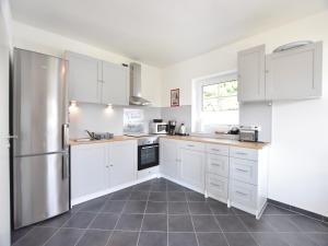 a kitchen with white cabinets and a stainless steel refrigerator at Apartment, Oldenburg in Holstein in Oldenburg in Holstein