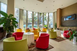 a restaurant with colorful chairs and tables and windows at Mondial Hotel Hue in Hue