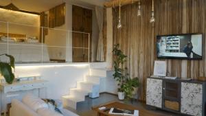 a living room with a couch and a tv and stairs at Apartamento Atalantar in Villanueva de la Vera