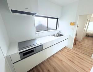a white kitchen with a sink and a window at 果実の見える宿 in Koshu +45 photos