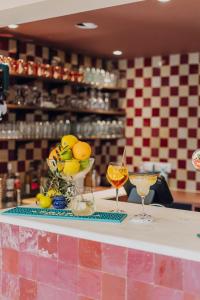 a counter with two wine glasses and oranges on it at Hotel Melba in Bastogne