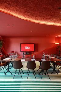a restaurant with tables and chairs and a red wall at Hotel Melba in Bastogne