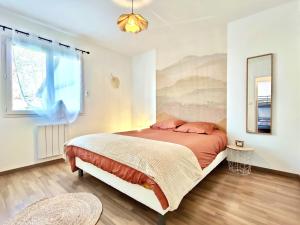 a bedroom with a bed and a window at L'Écrin d'Ussat in Ussat