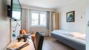 Kleines Zimmer mit einem Bett und einem Schreibtisch mit einem Schreibtisch. in der Unterkunft Almaas Hotell Stord AS in Stord + 21 Fotos