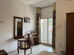 a living room with a mirror and a chair at Tenshin Residance. in Kandy