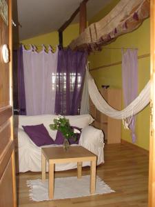 a bedroom with a bed with a table and purple curtains at Gîte les Peyrets in Montech