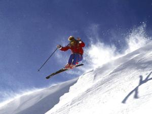 un hombre volando por el aire mientras esquiaba por una pista cubierta de nieve en Hotel Sunfuraton, en Furano