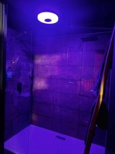 a room with a shower with a purple light at Love room location de 15h a 17h in Wattignies