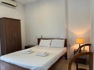 a bedroom with a bed with two towels on it at Tenshin Residance. in Kandy