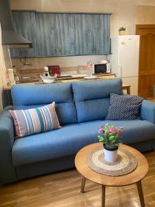 a blue couch in a kitchen with a table at Apartamento La Plazuela in Almagro