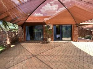 a brick house with a large umbrella over a patio at 5 Moepel in Potchefstroom