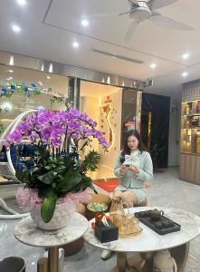 a woman sitting in a store looking at her cell phone at Sky Hotel in Ninh Binh