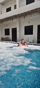 a man and a child swimming in a swimming pool at Camotes Hostel Resort Fan Rooms in San Francisco +13 photos