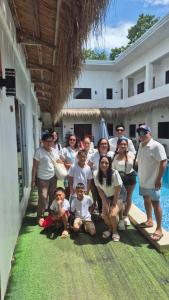 a group of people posing for a picture in front of a house at Camotes Hostel Resort Fan Rooms in San Francisco