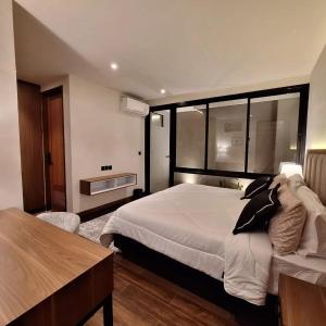 a bedroom with a large white bed and a table at Via Adonia Mezzanine in Ungasan