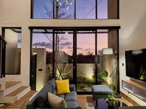 a living room with a couch and a large window at Via Adonia Mezzanine in Ungasan