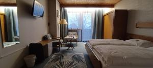 a hotel room with a bed and a desk and a table at Landhotel Jägerhof Bischofsgrün in Bischofsgrün